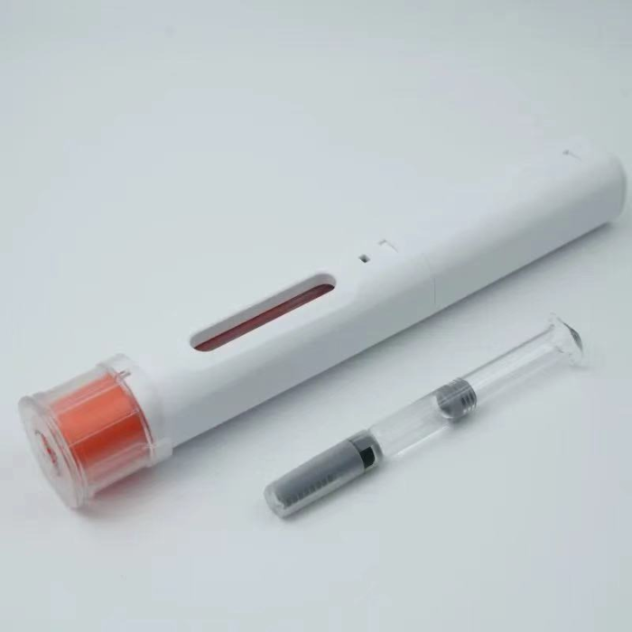 Top view of a medical injector pen next to a 1mL glass pre-filled syringe (PFS) for biologics delivery