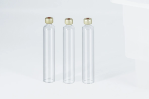 Three clear cylindrical glass cartridges sealed with gold-colored aluminum caps