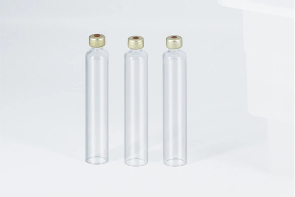 Three clear cylindrical glass cartridges sealed with gold-colored aluminum caps