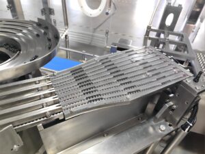 High precision nest positioning for automated prefilled syringe filling line.
